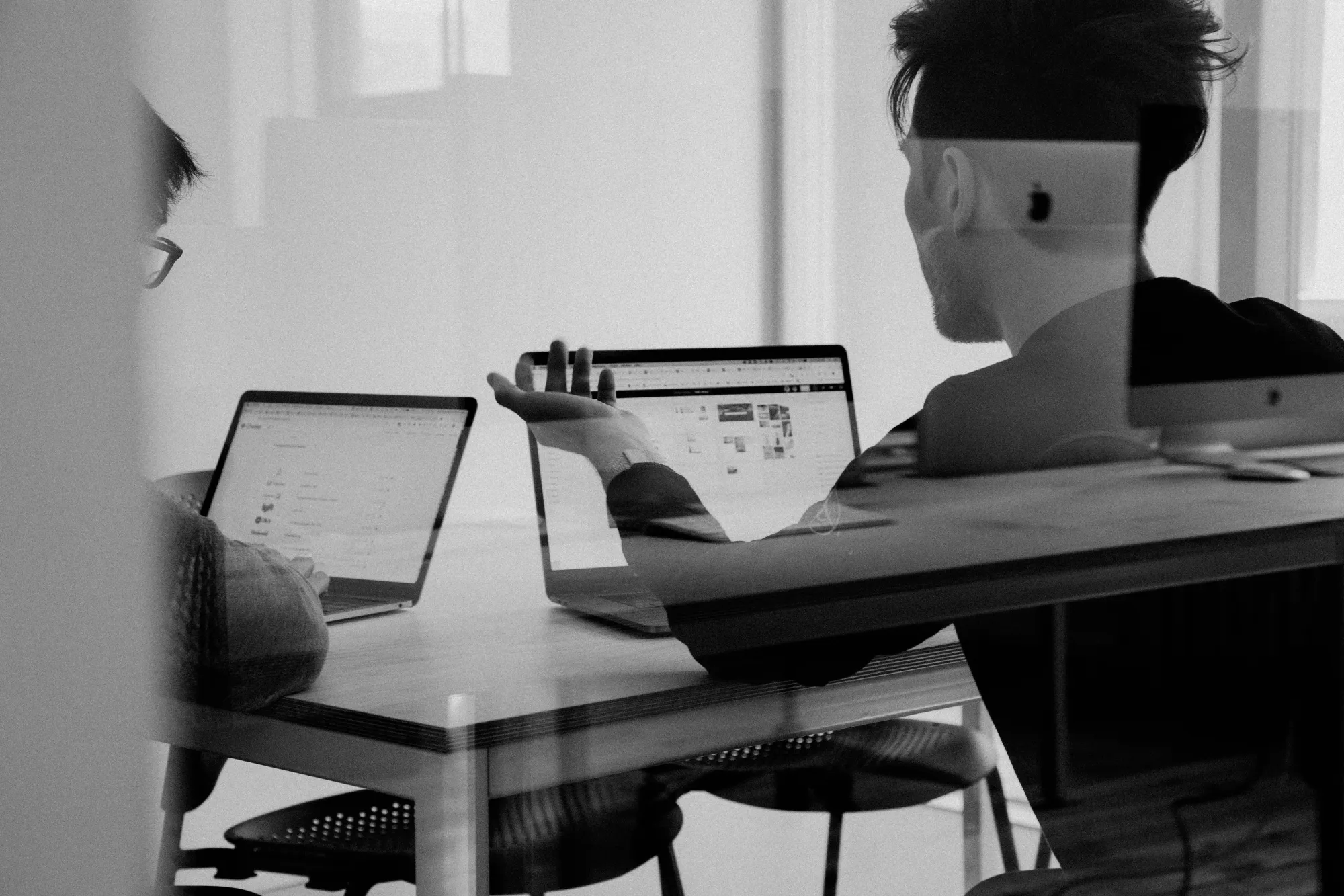 Two developers working on laptops in an office